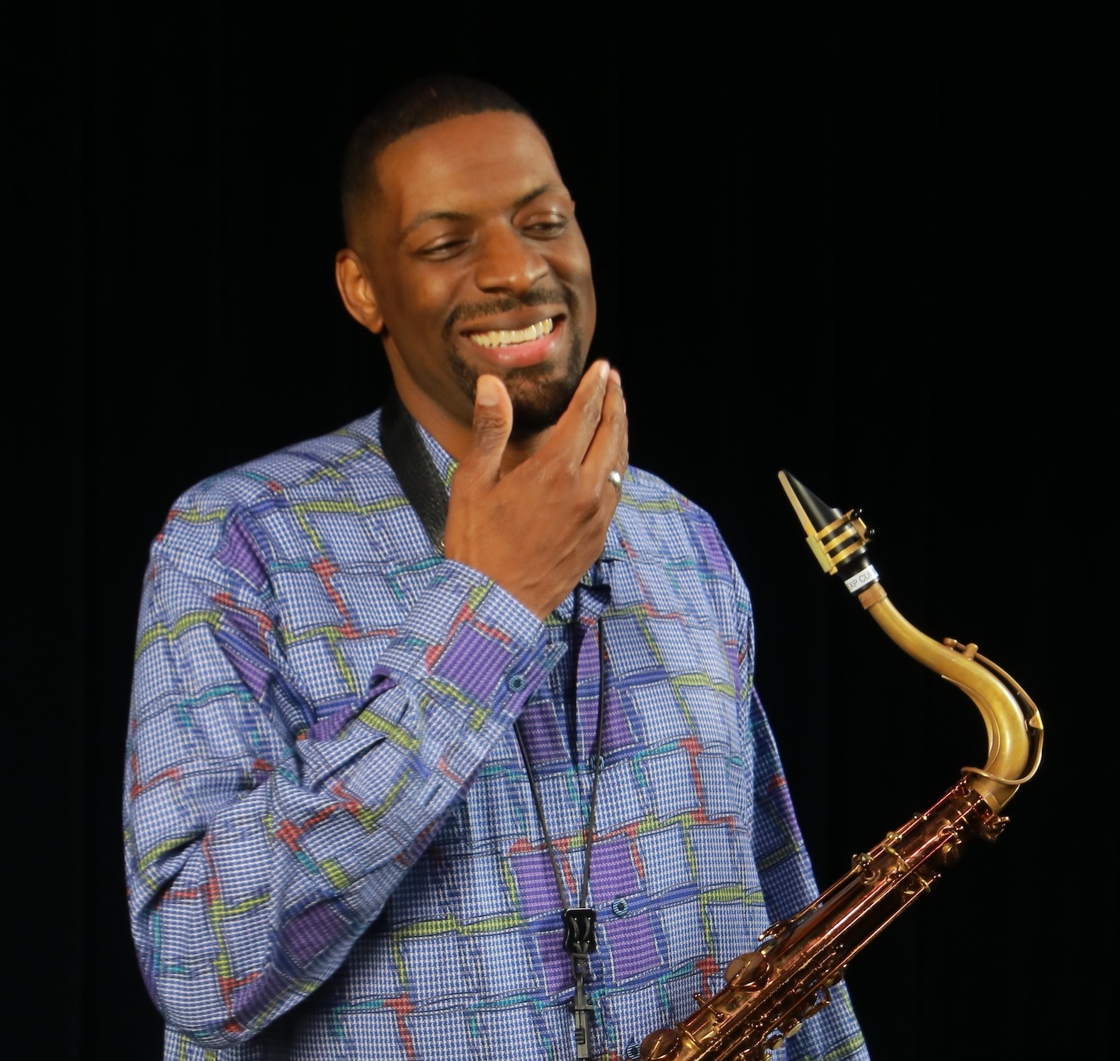 Quamon Fowler smiling with his saxophone